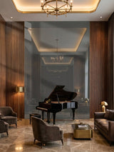 Large gray mirror wood veneer panel feature wall behind a grand piano in an elegant lounge