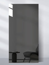 Gray Mirror Wood Veneer Panel in 9 x 4 ft size reflecting a dark lounge chair and side table