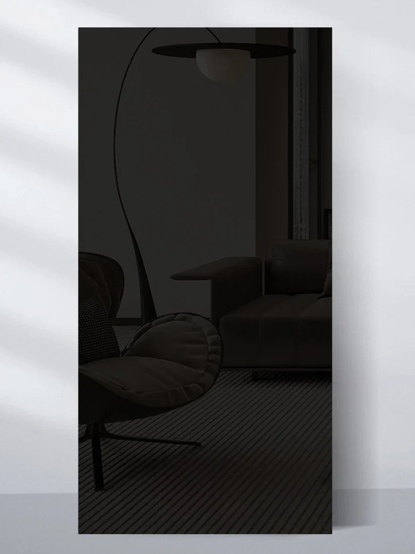 Dark glossy wood veneer wall panel sample reflecting a modern lounge chair, sofa, and floor lamp