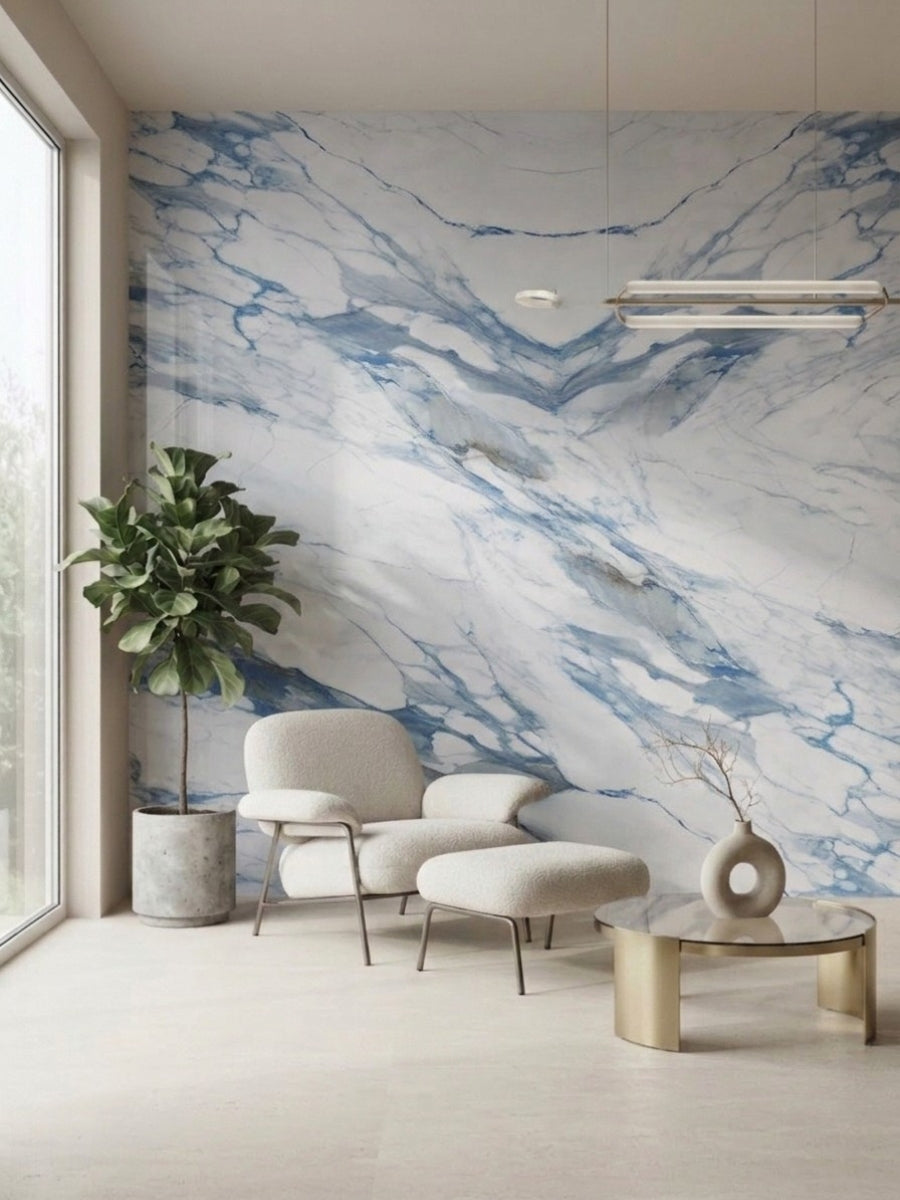 Calacatta Azur marble-look PVC wall panels installed behind a lounge chair, ottoman and side table