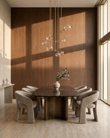 Walnut wood veneer panels covering a sunlit dining room wall behind an oval table