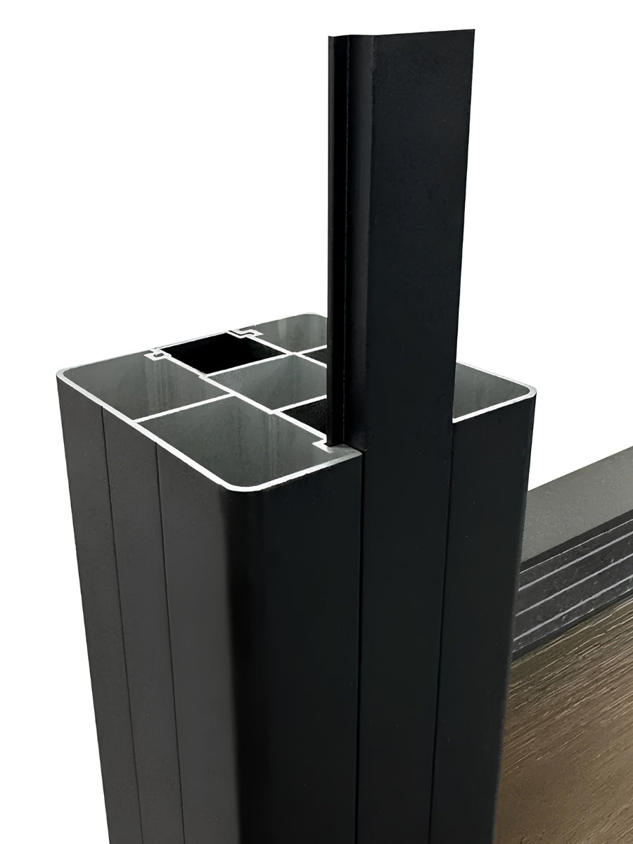 Close-up of a black fence slat inserted into the above-ground fence post channel
