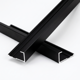Two crossed black aluminum alloy end cap trim pieces with exposed channel ends