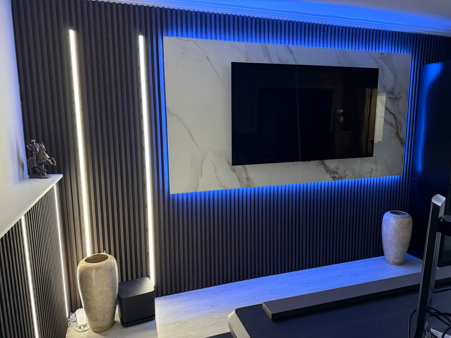 Modern living room with a television mounted on a wall with decorative lighting.
