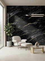 Midnight Gold Marble wall panel with white and gold veining behind a lounge chair, ottoman, and potted plant