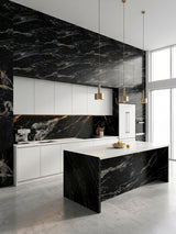 Modern white kitchen with Midnight Gold Marble panels across the backsplash, upper wall, and waterfall island
