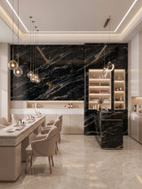 Bright modern dining space with Midnight Gold Marble wall panels, illuminated shelving, and pendant lights