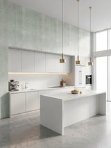 Rough-textured pale green travertine-look panels in a minimalist white kitchen