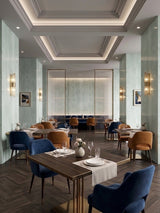 Pale green travertine-look wall panels installed in an elegant restaurant dining room