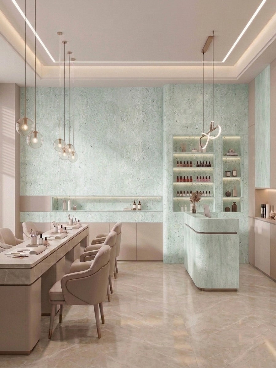 Rough-textured pale green travertine-look panels covering a modern salon wall and counter