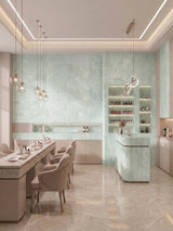 Rough-textured pale green travertine-look panels covering a modern salon wall and counter