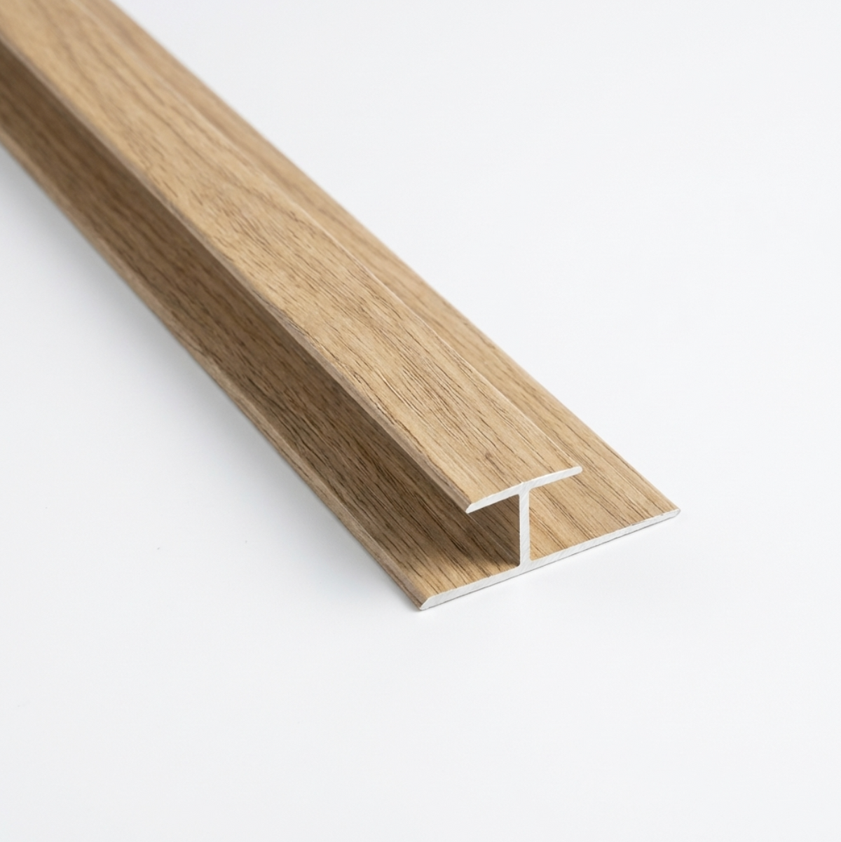 Close-up of a T-shaped wood-grain connector trim for white oak veneer wall panels