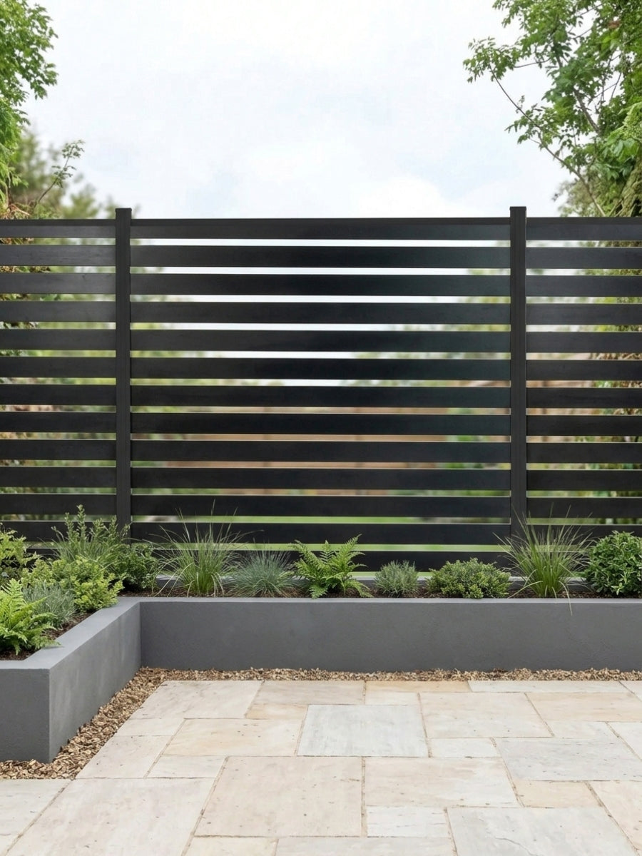 All-aluminum horizontal open slat fence installed behind raised garden beds and a stone patio
