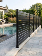 Dark horizontal slat aluminum fence panels installed along a backyard swimming pool