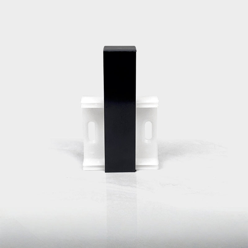 Black aluminum LED skirting baseboard channel, surface-mounted on white wall with brackets.
