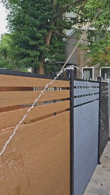 Brown composite fence with wood grain texture, supported by black metal posts, perfect for NJ backyards.